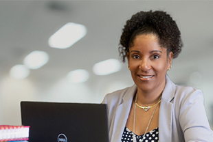 A women smiling in front of an laptop