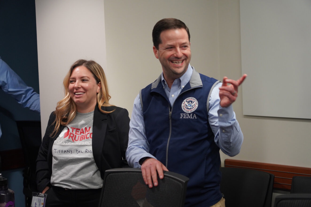 Man in FEMA vest laughing and gesturing.