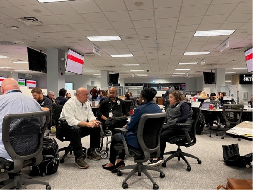 Federal Coordinating Officer Timothy S. Pheil discussing the disability integration strategy for the Hurricane Helene response with FEMA Disability Coordinator Sherman Gillums Jr. along with state access and functional needs staff in the situation room at the Virginia Emergency Operations Center.